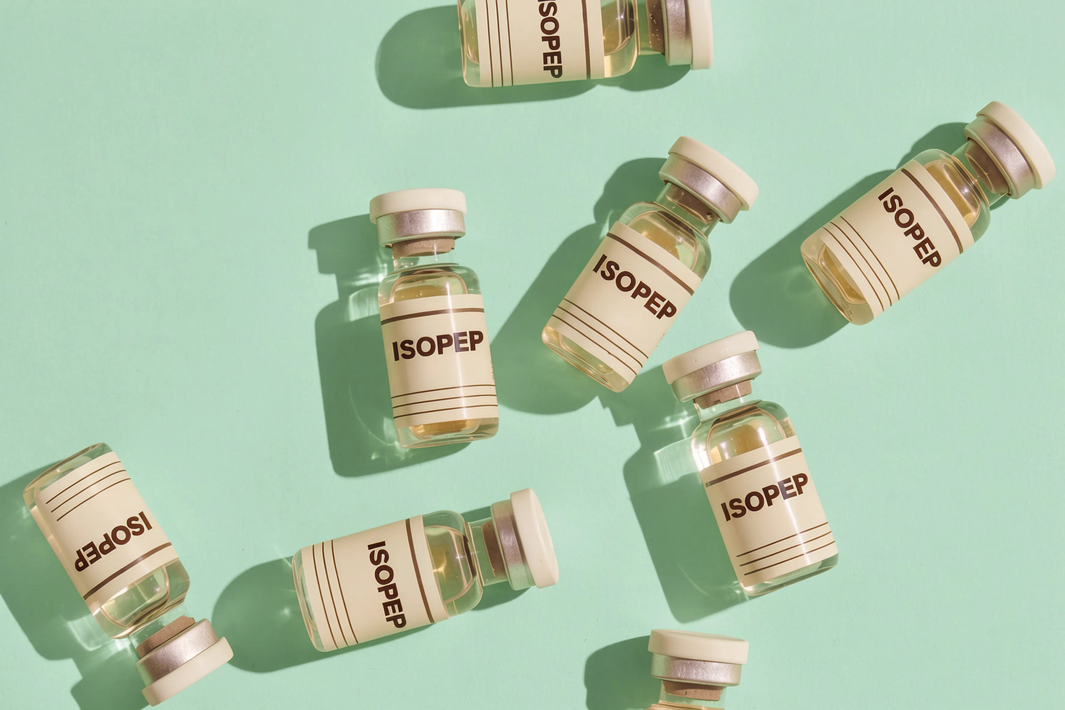 Multiple ISOPEP vials arranged on a mint green surface
